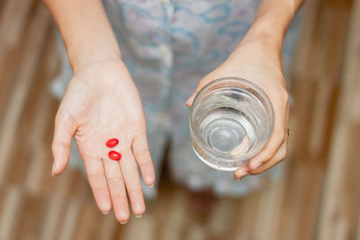 Midsection of woman taking medicine at home