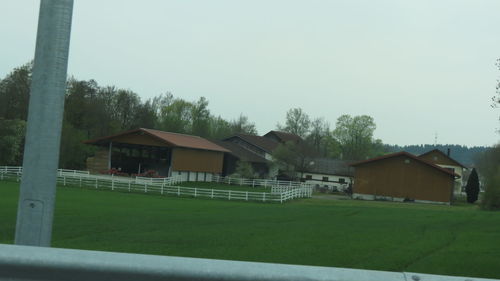 Barn by houses against clear sky