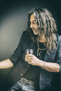 Man holding drinking glass on black background