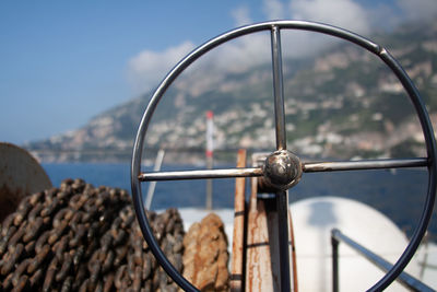 Close-up of rusty wheel against sky