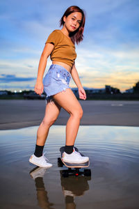 Asian women playing surf skate or skates board outdoors.