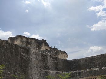 Low angle view of rock formations against sky