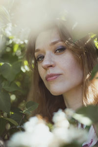 Close up woman with bright makeup surrounded by white flowers portrait picture