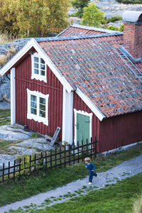 Boy running near wooden house