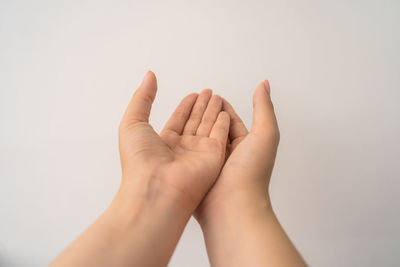 Close-up of hands against white background