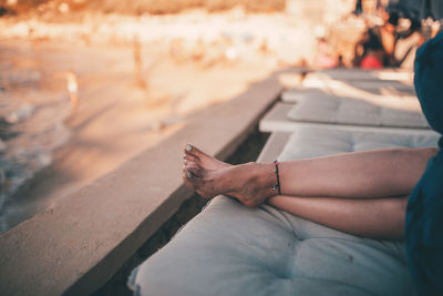 Midsection of man using mobile phone while sitting outdoors