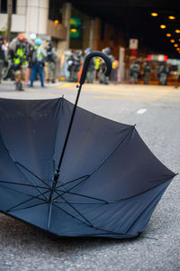 Close-up of wet umbrella on street during rainy season