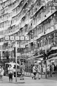 People walking on street amidst buildings in city