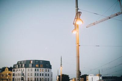 Low angle view of illuminated street light against clear sky at dusk in city