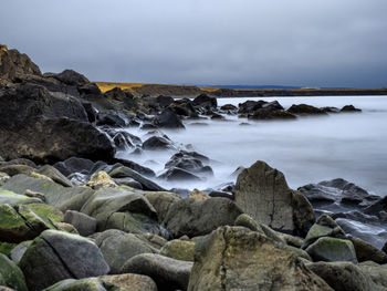 Rocks in sea against sky