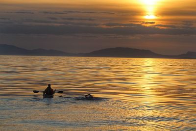 Sunset swimmer and kayaker in isle of harris