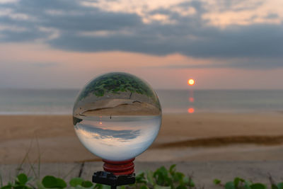 Close-up of water on beach against sky during sunset