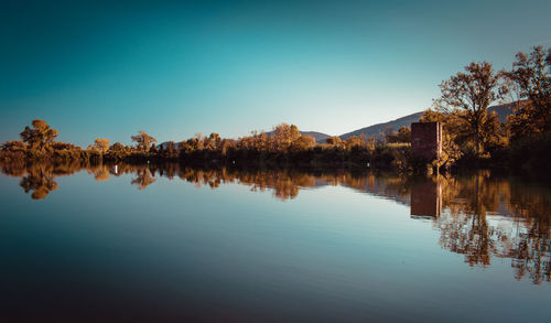 Scenic view of lake against clear blue sky