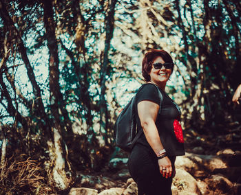 Young woman wearing sunglasses in forest