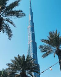 Low angle view of skyscraper against blue sky