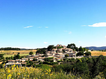 Buildings on field against sky