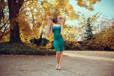 Full length of woman standing by tree