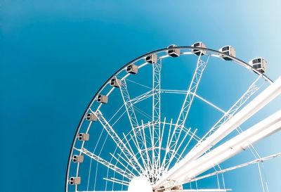 Low angle view of ferris wheel against blue sky