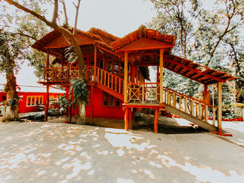 Gazebo in park by building against sky