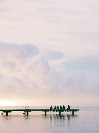 Group of people sitting on pier