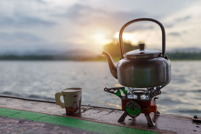 Close-up of kettle on stove against sky