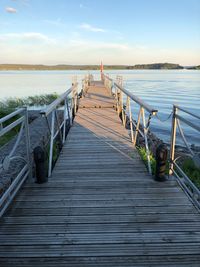 Wooden pier leading towards sea against sky