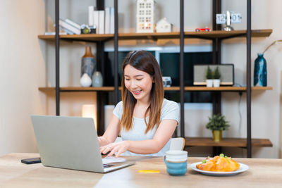 Young woman using laptop at table