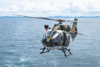 Rear view of man flying over sea against sky