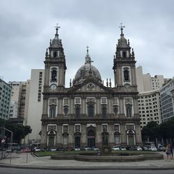 View of buildings in city against cloudy sky