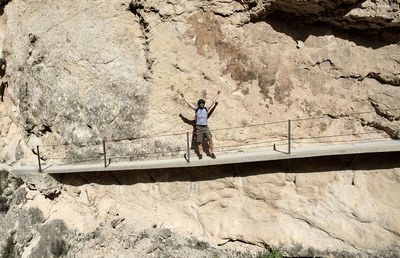 Low angle view of young man walking on footbridge