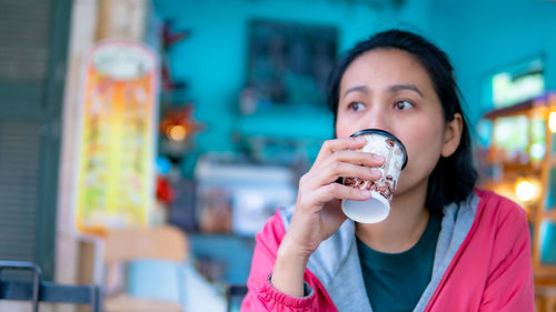 Portrait of young woman drinking ice cream