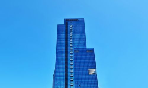 Low angle view of modern buildings against clear blue sky
