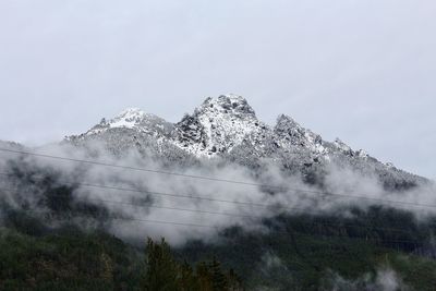 Low angle view of snowcapped mountains against sky