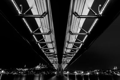 Low angle view of bridge over river at night