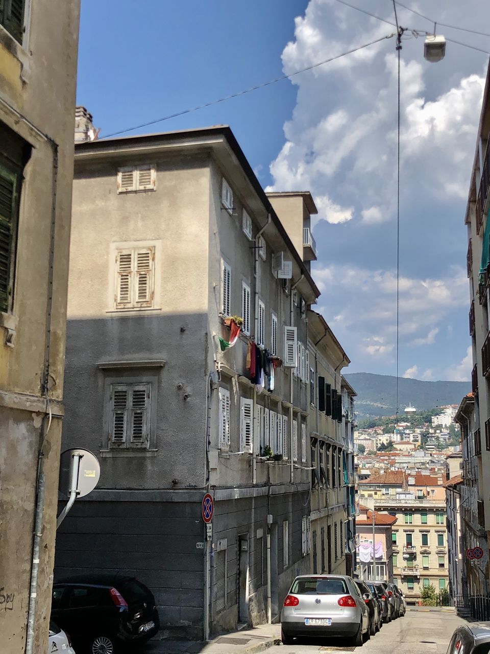 CARS ON ROAD AMIDST BUILDINGS IN CITY