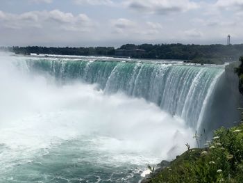 Scenic view of waterfall against sky