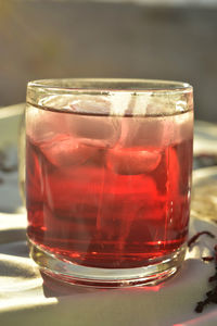 Drinking glasses of ice cubes and red iced tea made with hibiscus flower petals  or fleur de jamaica