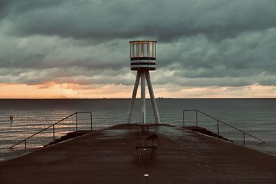 Pier over sea against sky during sunset