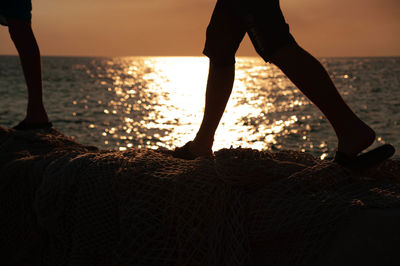 Low section of man standing on beach