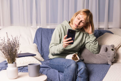 Portrait of woman sitting on sofa at home