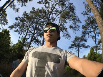 Low angle view of man standing against trees