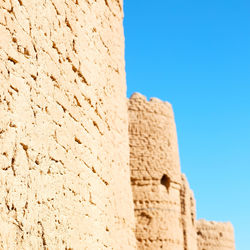 Low angle view of wall against blue sky