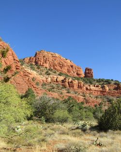 Rock formations on landscape against clear blue sky