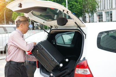 Midsection of man standing in car