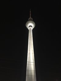 Low angle view of communications tower in city against sky