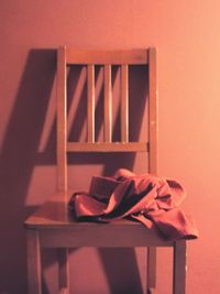 Close-up of empty chair on table against wall