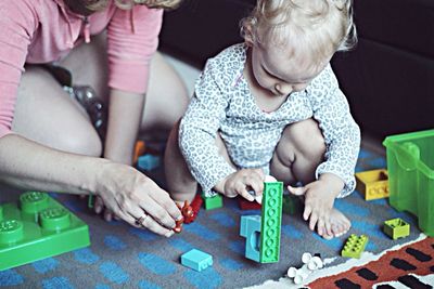 Low section mother playing with child at home