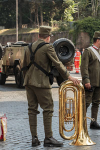 Marching band with wind instrument standing on street