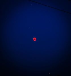 Low angle view of moon against blue sky at night