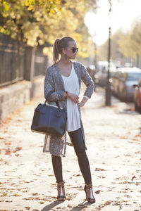 Young woman standing on footpath